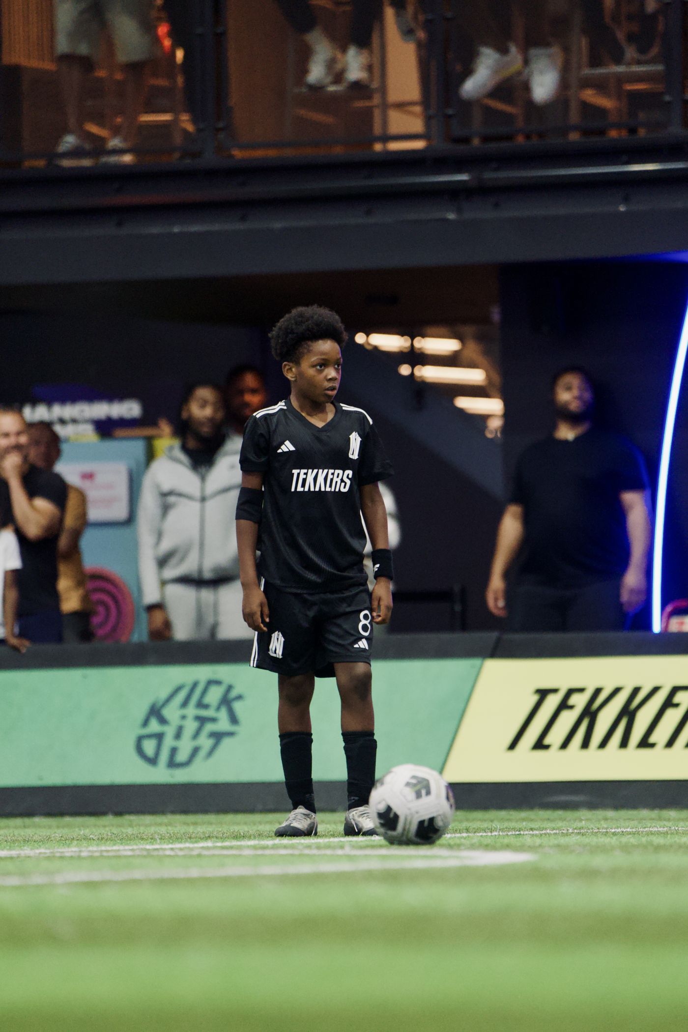 Young player in Tekkers kit on an indoor pitch with the Tekkers board behind him